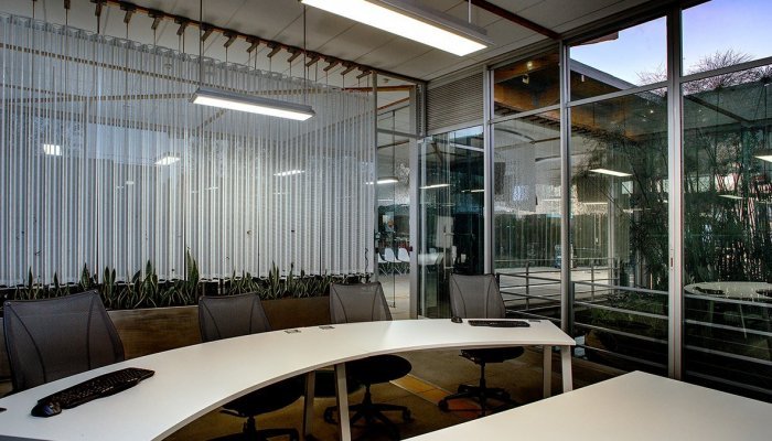 Vodacom’s Midrand Innovation Centre has the appearance of a transparent glass box with overhangs, natural ventilation, low-energy design with solar installation, and an inner ‘wetland’ courtyard, designed to achieve a biodiverse site of which 70% was covered in indigenous and endemic vegetation. 